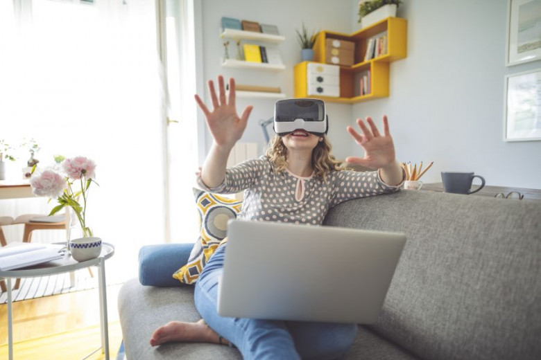 Ženska z virtualnimi očali pred računalnikom