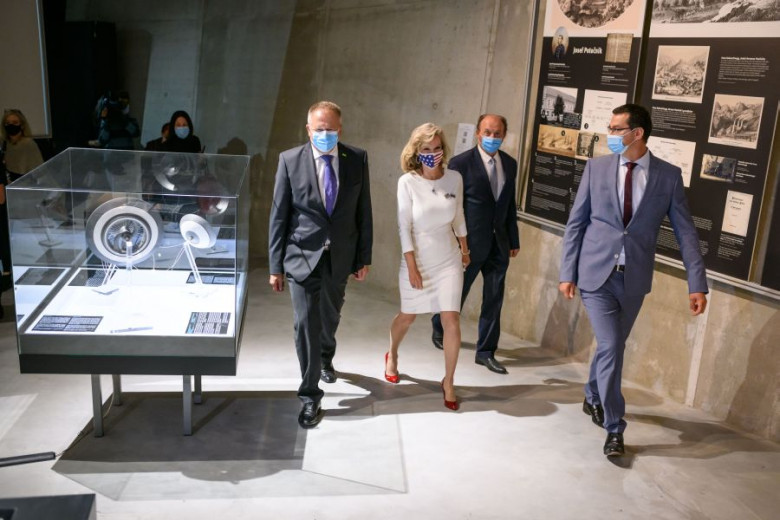 The director, the mayor, the ambassador and the minister go to the opening place of the exhibition.