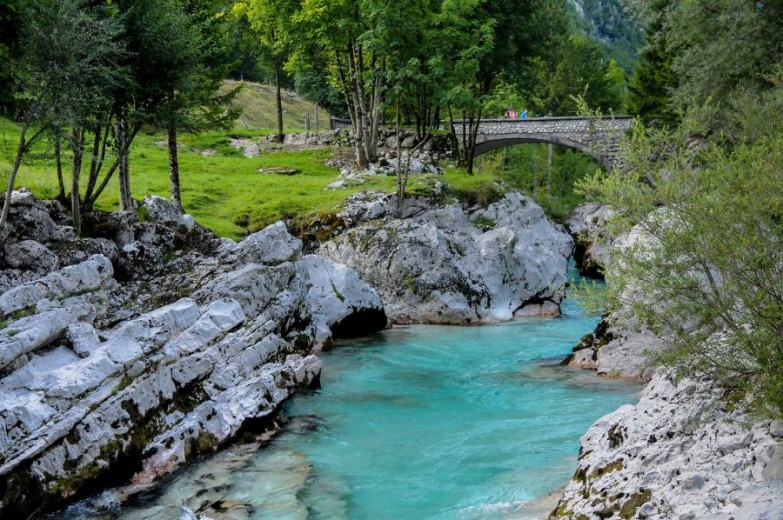 A turquoise river, with green trees on the sides.