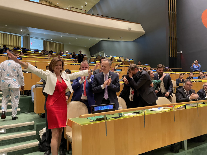 The Minister with her hands in the air with her team at the announcement in the UNSC.