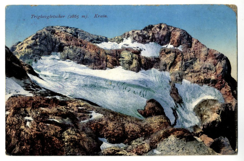 An old postcard depicting a steep, rocky mountain slope beneath Triglav, Slovenia’s highest peak, covered in snow.