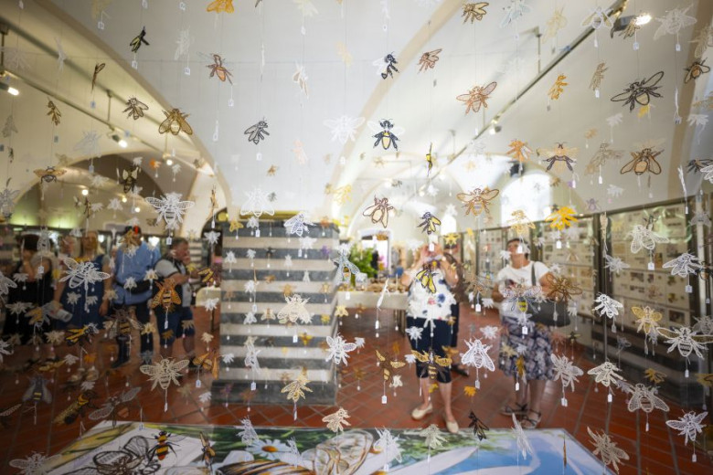 Bees, made out of Idrian lace, on threads, hanging from the ceiling, at a lace display. 