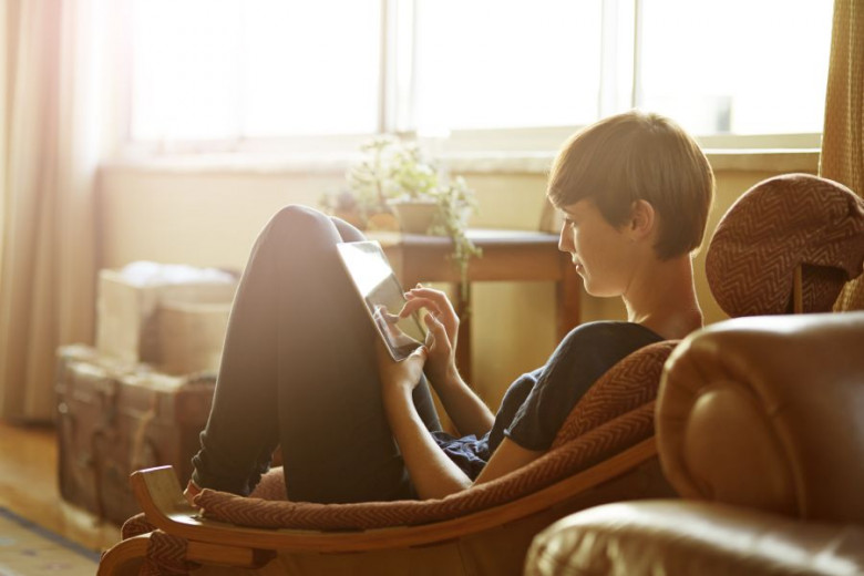 Young woman relaxing at home with tablet
