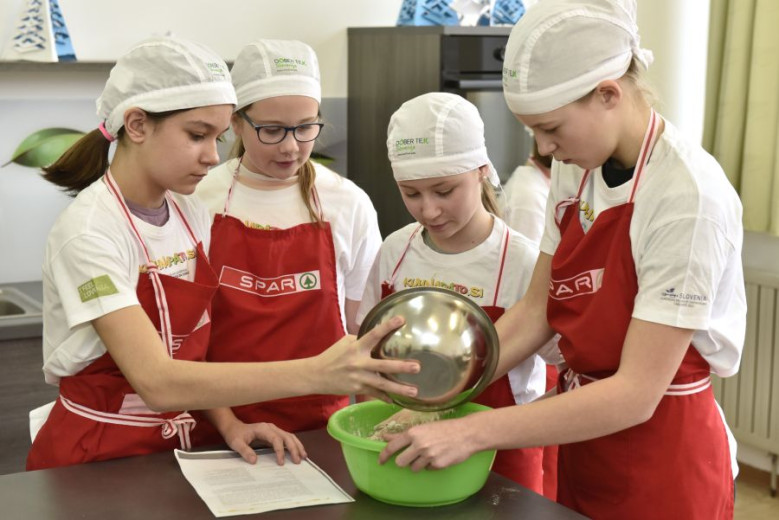 The girls shake the ingredients into the bowl.