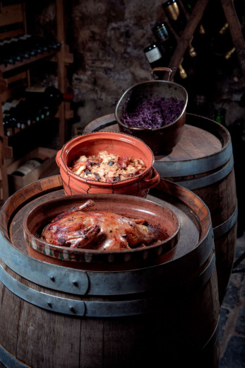 There are bowls of roast goose, mince and braised red cabbage on wine barrels.