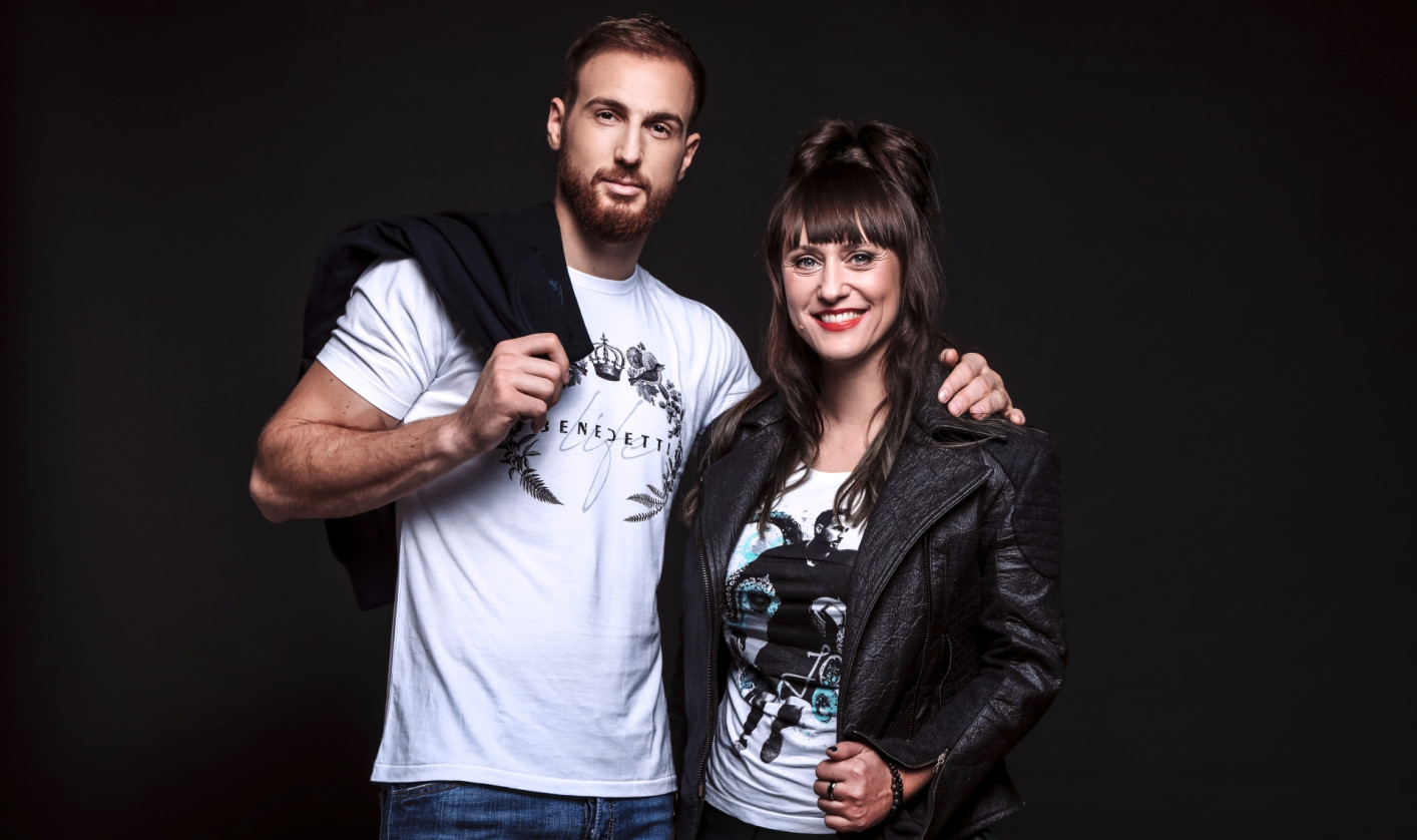 A portrait of the designer and the football player, Jan Oblak and Matea Benedetti, standing next to each other and smiling in the camera. 