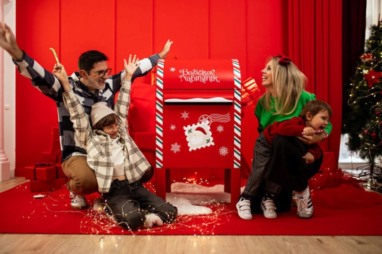 Happy familily around Santa's mailbox.