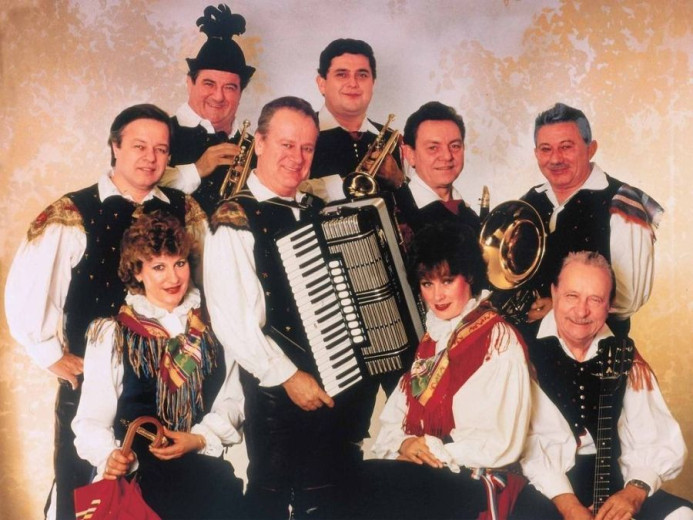 A group of men musicians and one of them has in his hands diatonic button accordion