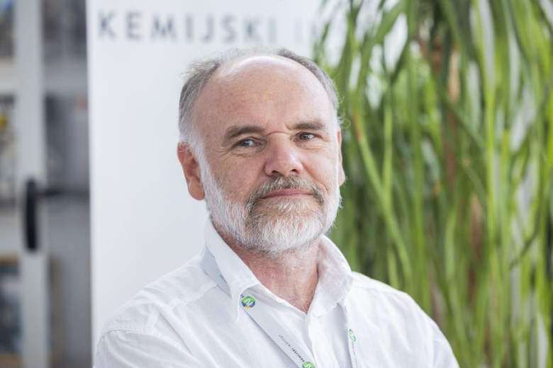 Portrait of Roman Jerala, gazing forward with a neutral expression, wearing a white shirt.