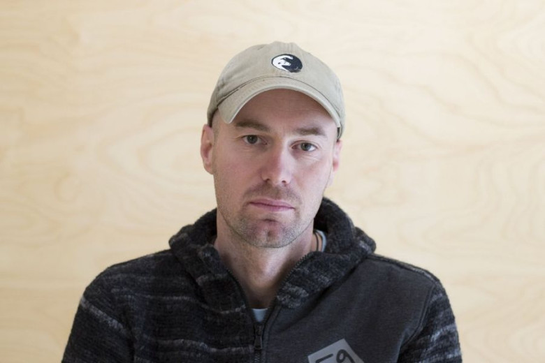 Researcher Miha Krofel in a black and grey sweather wearing a cap