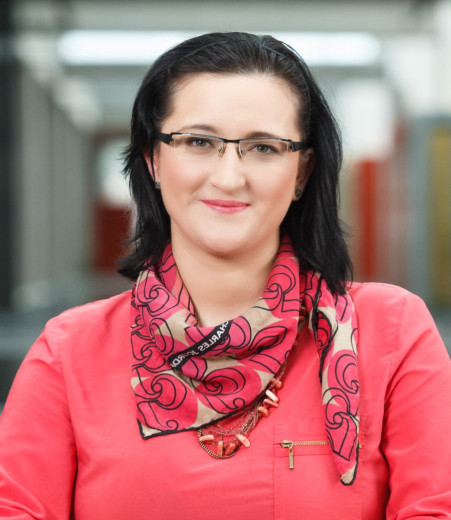 Marinka Žitnik with dark hair, wearing glasses and a pink scarf around her neck.