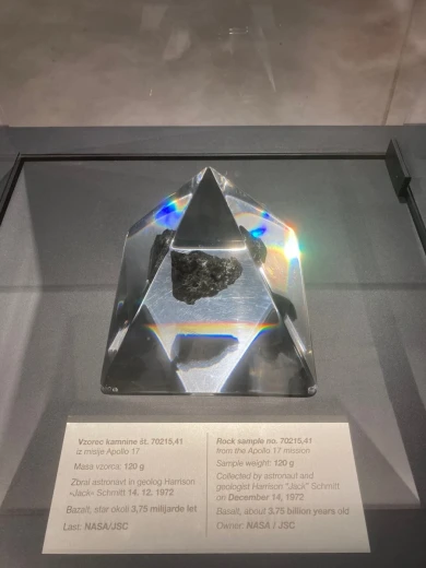 Black stone in a transparent pyramid at an exhibition.