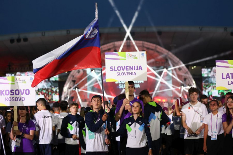  Athletes with the flag of the Republic of Slovenia and a sign with the inscription Slovenia.