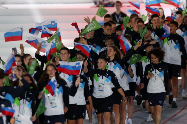 A parade of young athletes with Slovenian and I feel Slovenia flags.