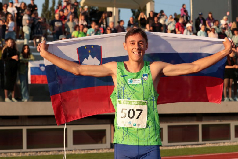 Žan Ogrinc is holding a Slovenian flag in his hands.