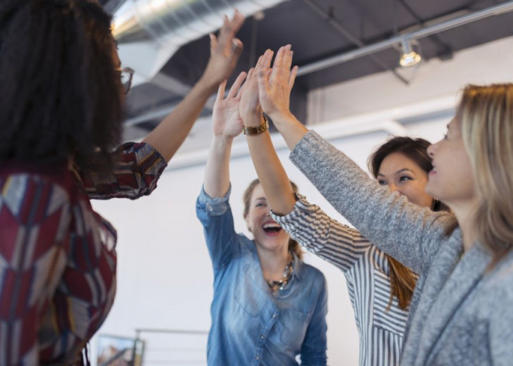 Businesswomen high fiving in conference room