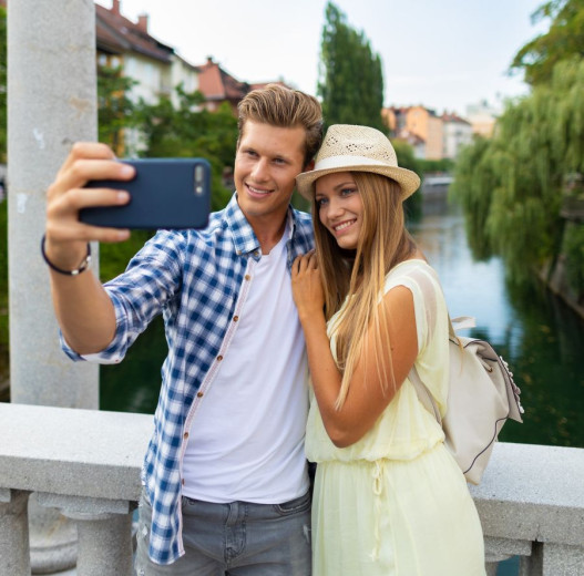 A couple is making selfie with the mobile phone at the Ljubljanica river