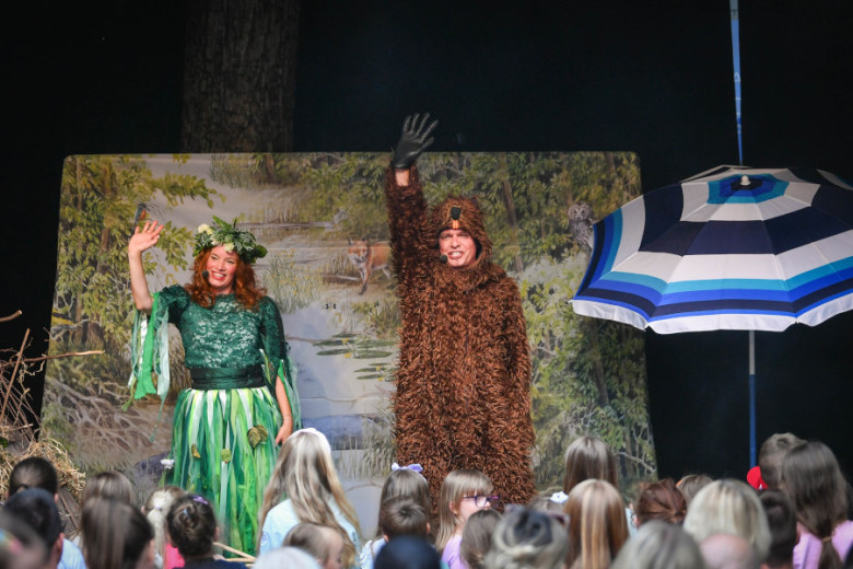Children are watching a performance on the stage.