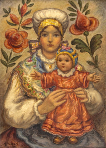 Mother in traditional costume is holding a little child in her hands.