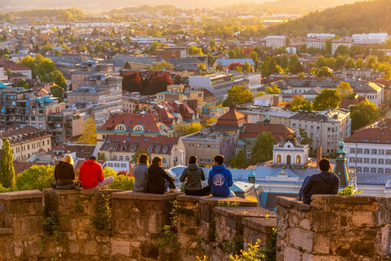 Children sitting on the walls. View of Ljubljana.