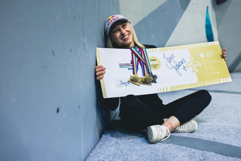 A sportsman girl  sitting on the floor and has a big peace of paper as a ticket for the Olympic games in Paris