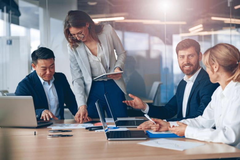 Woman is explaining something on the paper to the group of business people