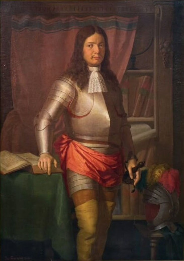 A man with long curly hair wearing a knight's armor.