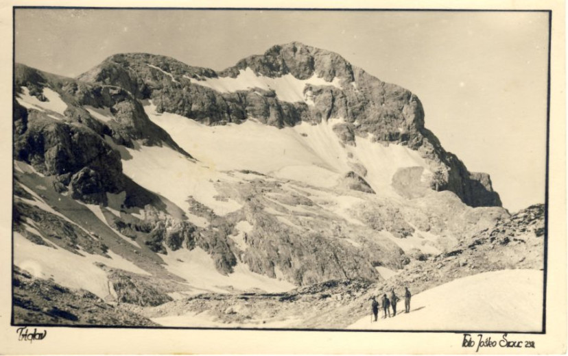 An archive photo that shows a steep, rocky mountain slope beneath Triglav, Slovenia’s highest peak, that is covered with a vast patch of snow.