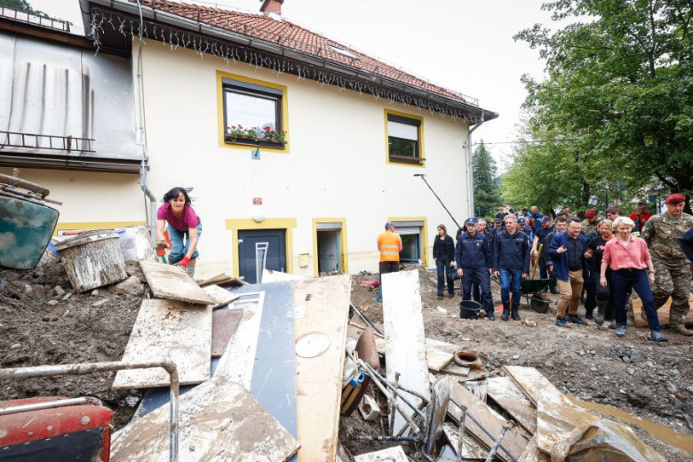 This photo shows the flooded street in town Črna na Koroškem during the visit of he President of the European Commission, Ursula von der Leyen and Slovene Prime Minister Dr. Robert Golob. They are accompanied by civil protection and army members. 