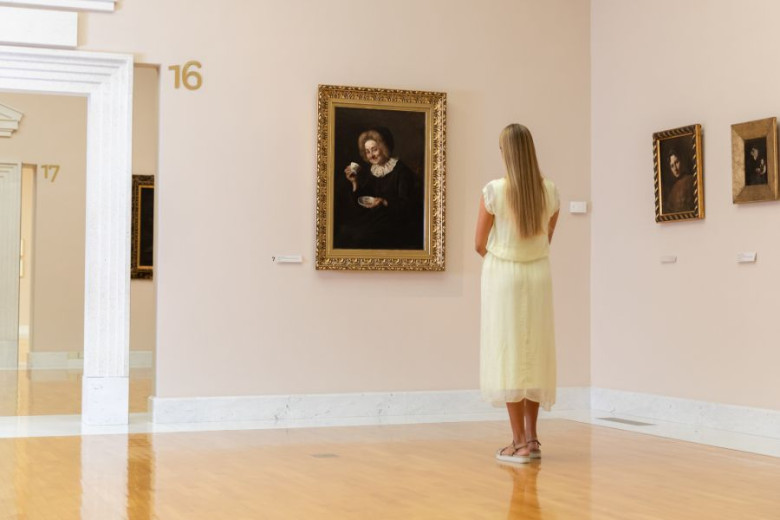 Woman looking at the painting in the gallery. 