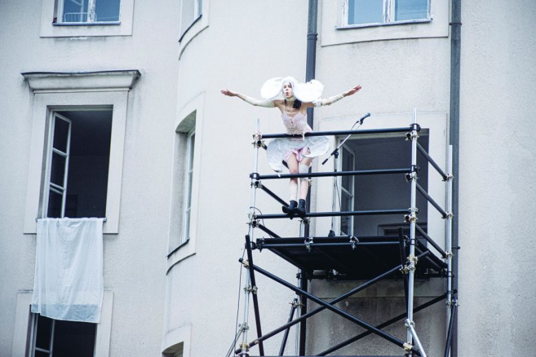 Woman dressed as angel at the balcony. 