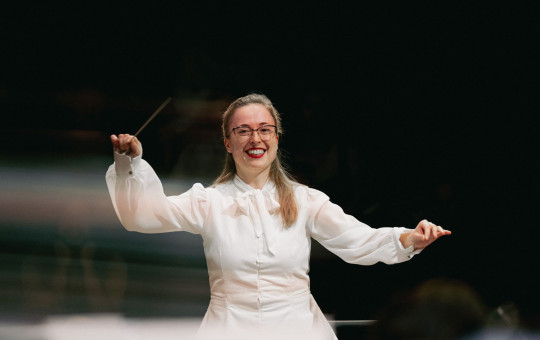 Dirigentka Mojca Lavrenčič med vodenjem orkestra na tekmovanju La Maestra v Parizu.