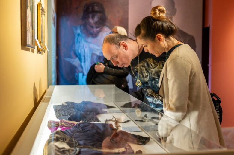 A man and woman are looking exponats under the glass in the museum