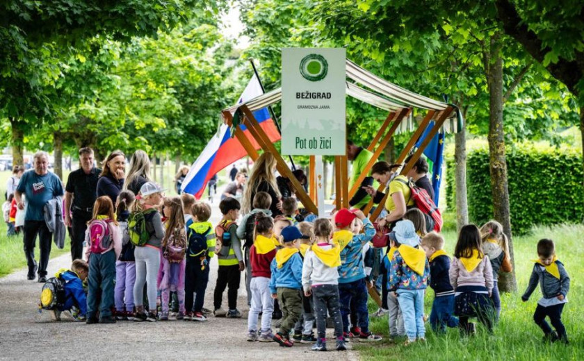 A group of the children from the kindergarden at the stell are drinking water and resting 