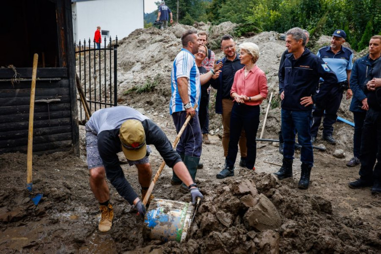 People are cleaning, removing mud. Ursula von der Leyen is talking to a local. Next to her is the Prime Minister Dr. Robert Golob.