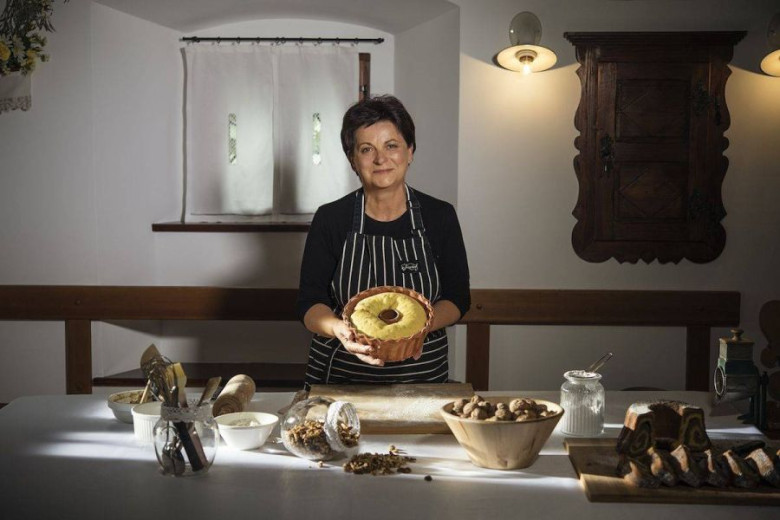 A woman is standing with the rolled cake in her hands