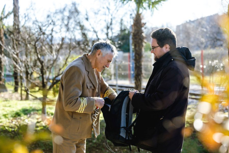 A man in the uniform is checking a bag of the man standing in front of him