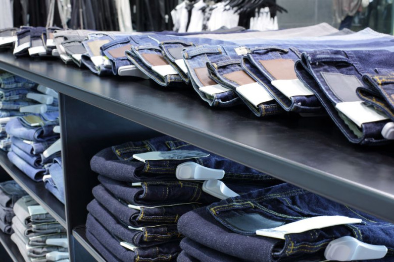 Piles of folded jeans on the shelves in a store