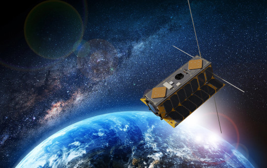 Satelit kroži nad Zemljo v vesolju.