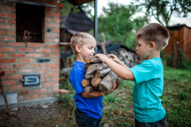 Two kids with firewood.
