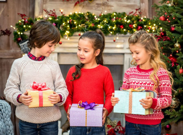 Two girls and a boy with the gifts in their hands