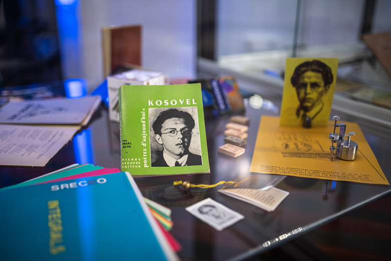 Books, photographs and small personal items displayed in a glass display case.