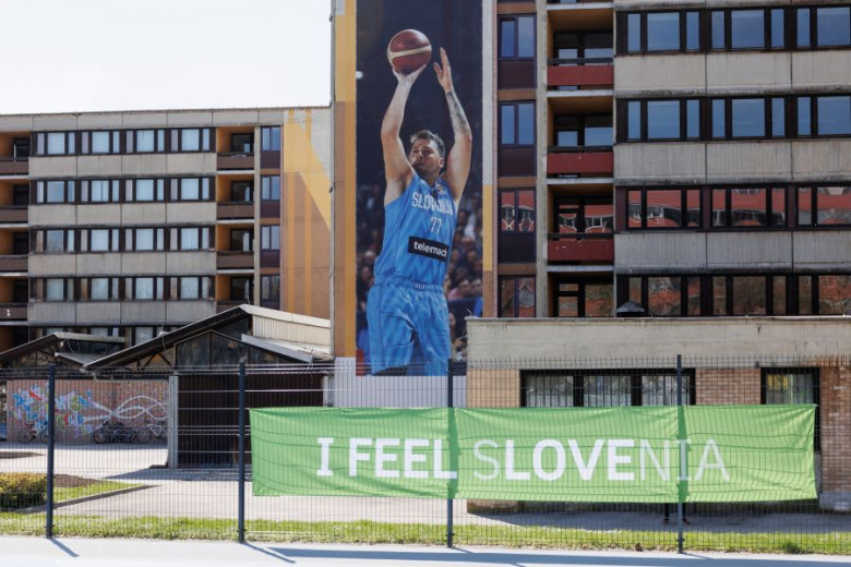 Pogled na plakat Luke Dončića na stolpnici, pod njim transparent I feel Slovenia.