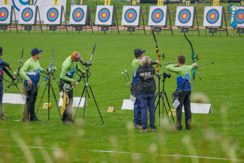 Archers stand in a line and prepare to shoot at the targets.