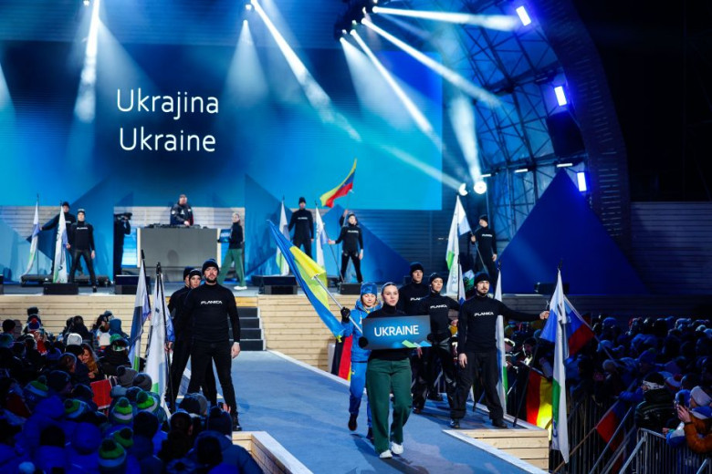 A Ukrainian national team member passes by with their flag. Photo: Anže Malovrh, STA.