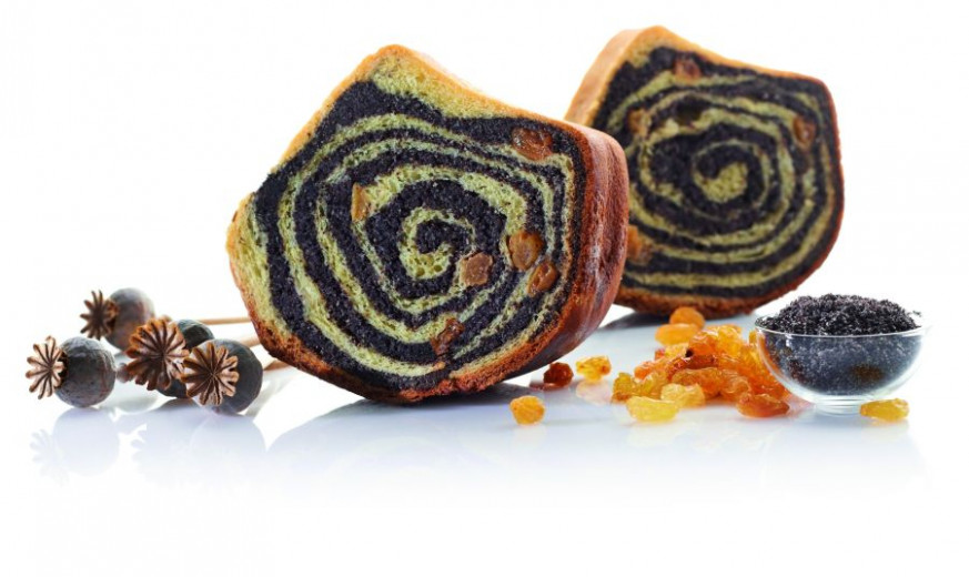 Poppy seed cake on a plate with raisins and poppy seeds.