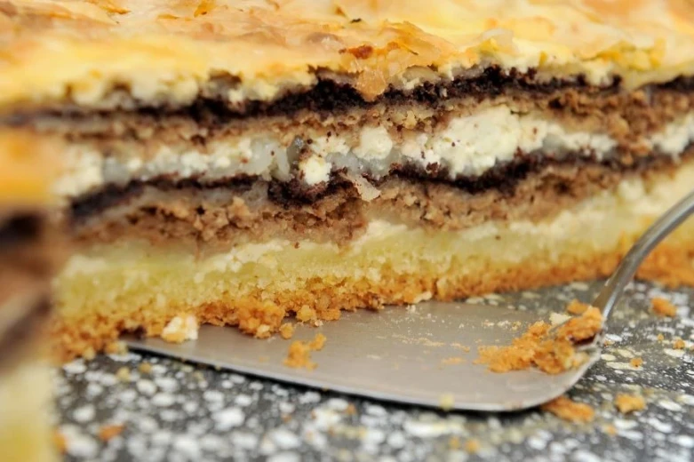 Close-up of prekmurska gibanica with layers of walnut filling, poppy seeds, apple filling, and cottage cheese filling. 