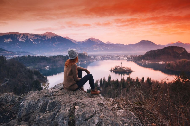 Young woman looking on sunset on Bled Lake.