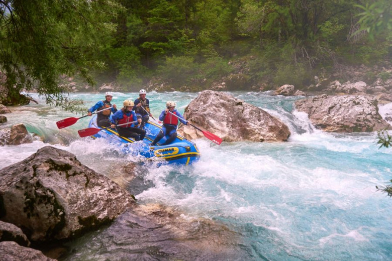 People on a raft on the rapids of a river.