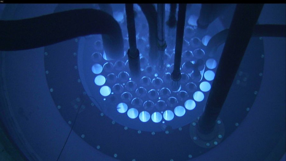 The reactor core glows with a blue light beneath the water.